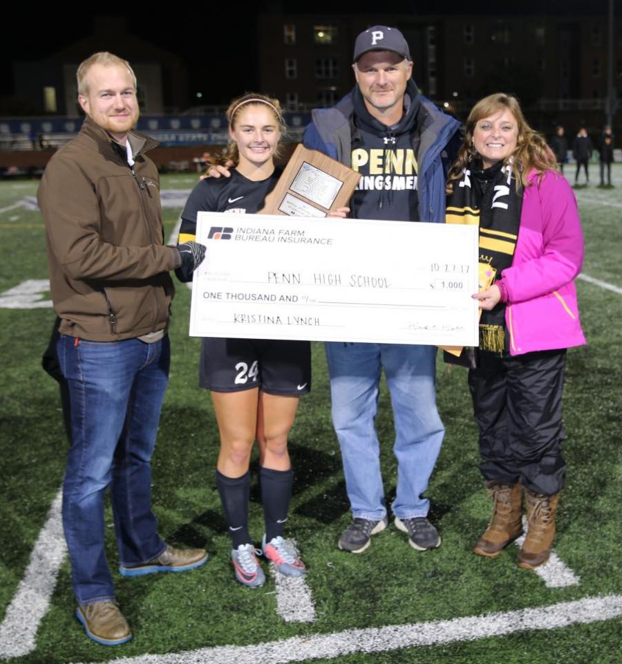 An IHSAA representative presents the IHSAA Mental Attitude Award to Penn's Kristina Lynch and her parents